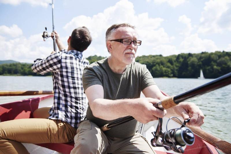 Two men fishing in a boat together.