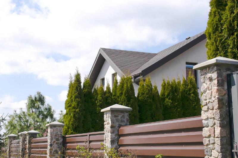 Tall privacy fence in front of a house.
