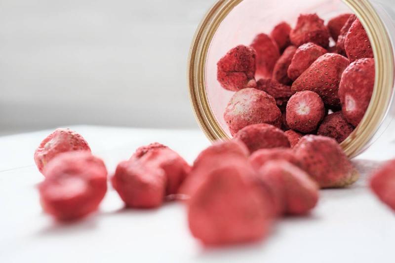 Dry sublimated strawberry scattering out of a jar.
