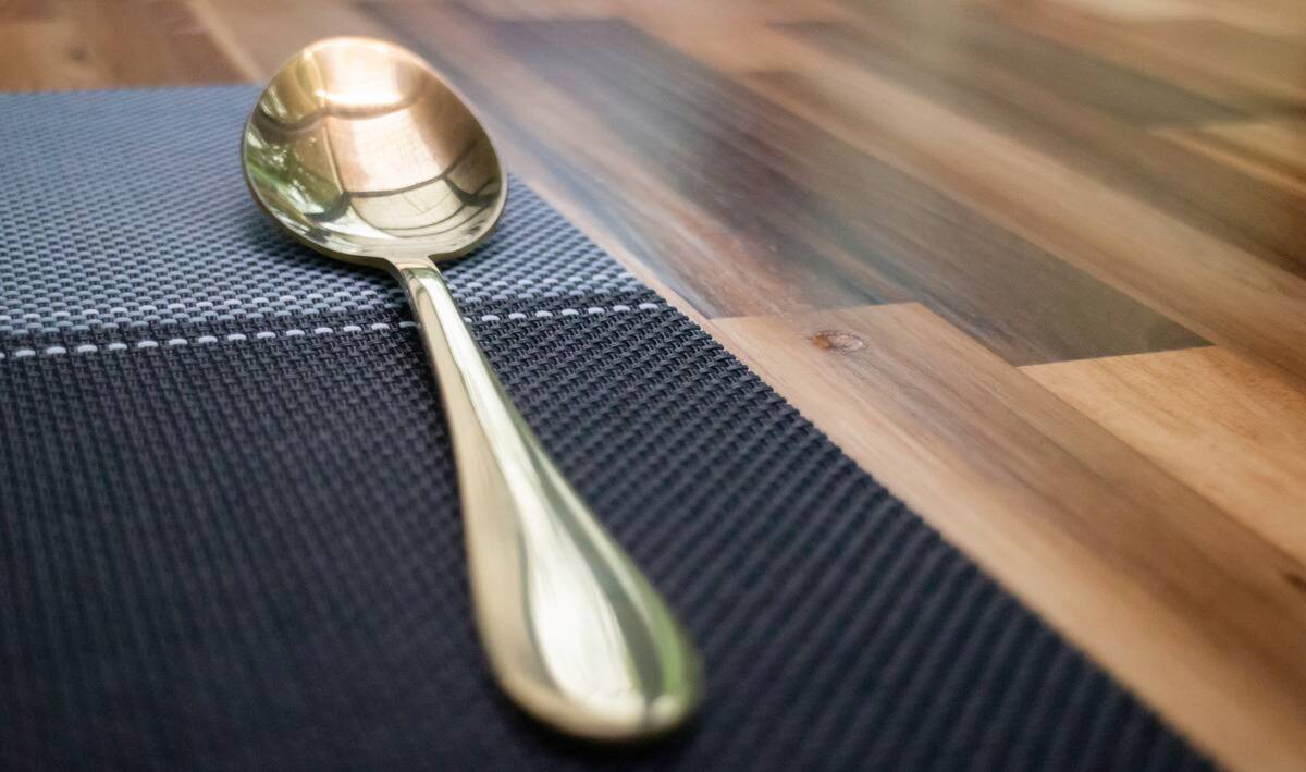A low angle shot of a spoon on a placemat.