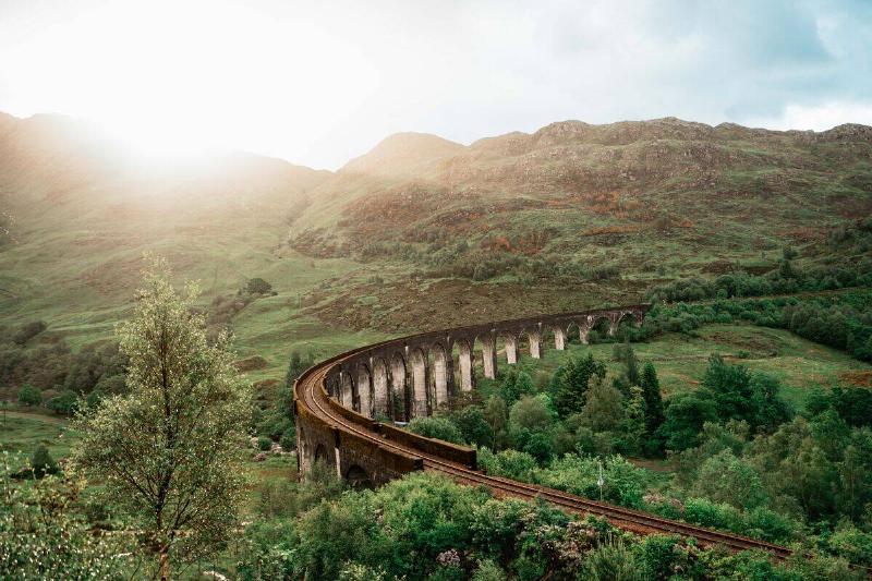 The famous Glenfinnan Viaduct in scenic highlands of Scotland on a sunny day