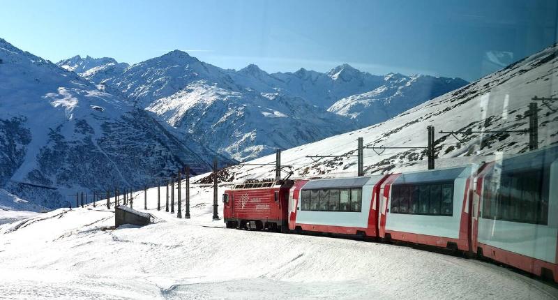 Glacier Express train east of Andermatt in Swiss Alps en route to Zermatt