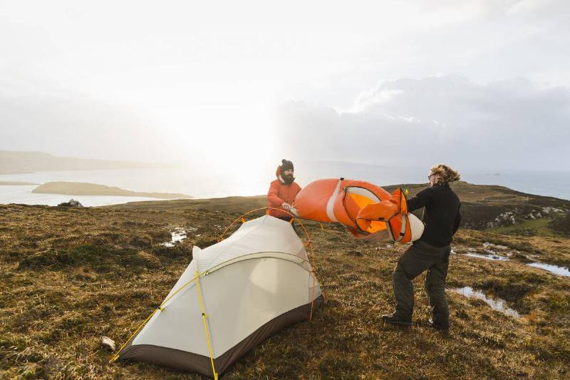 Two men setting up a small tent.
