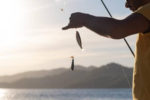 Man fishing from a boat on a lake.