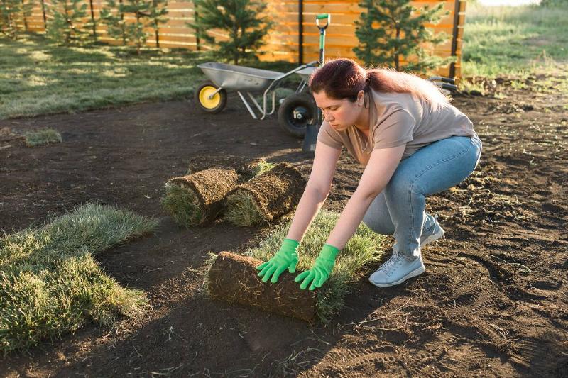 Woman laying out turf.