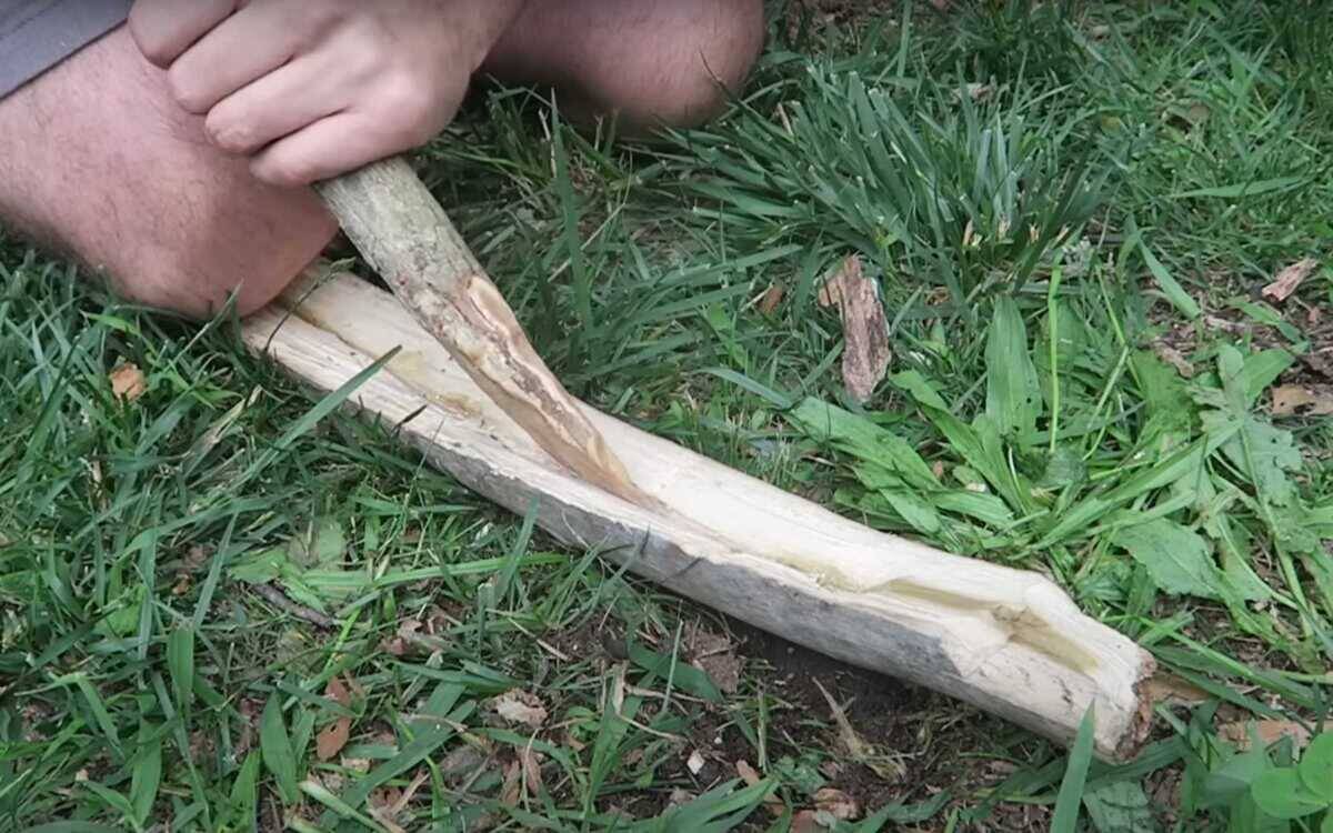 A man performing the Fire Plough method of starting a fire.