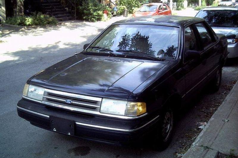 Ford Tempo parked along the side of a road