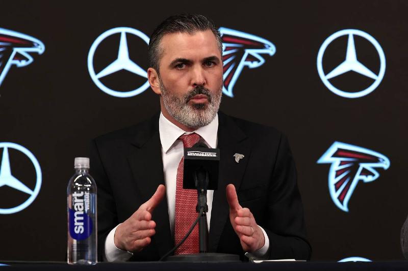 Kevin Stefanski sitting at a table, with a microphone and water bottle in front of him