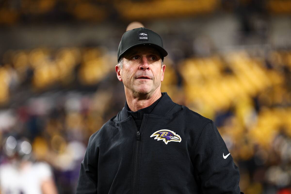 John Harbaugh standing in the middle of a football stadium