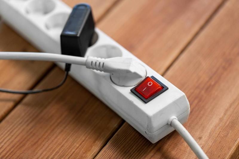 A close view of a power strip, two things plugged into its sockets.