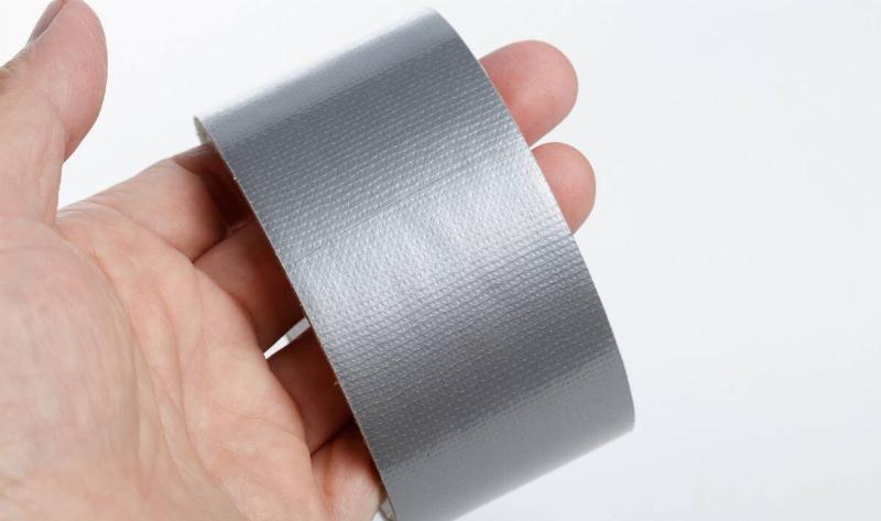 A closeup of a person holding a roll of duct tape.