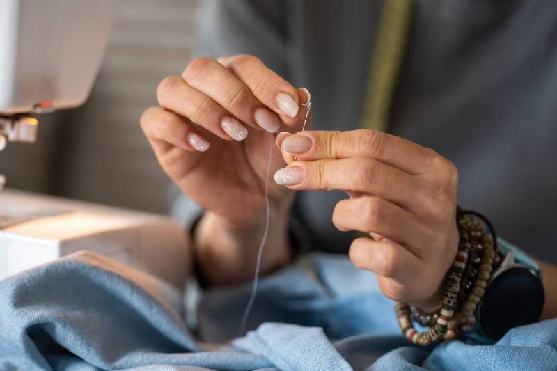 Close-Up Of A Woman Threading A Needle