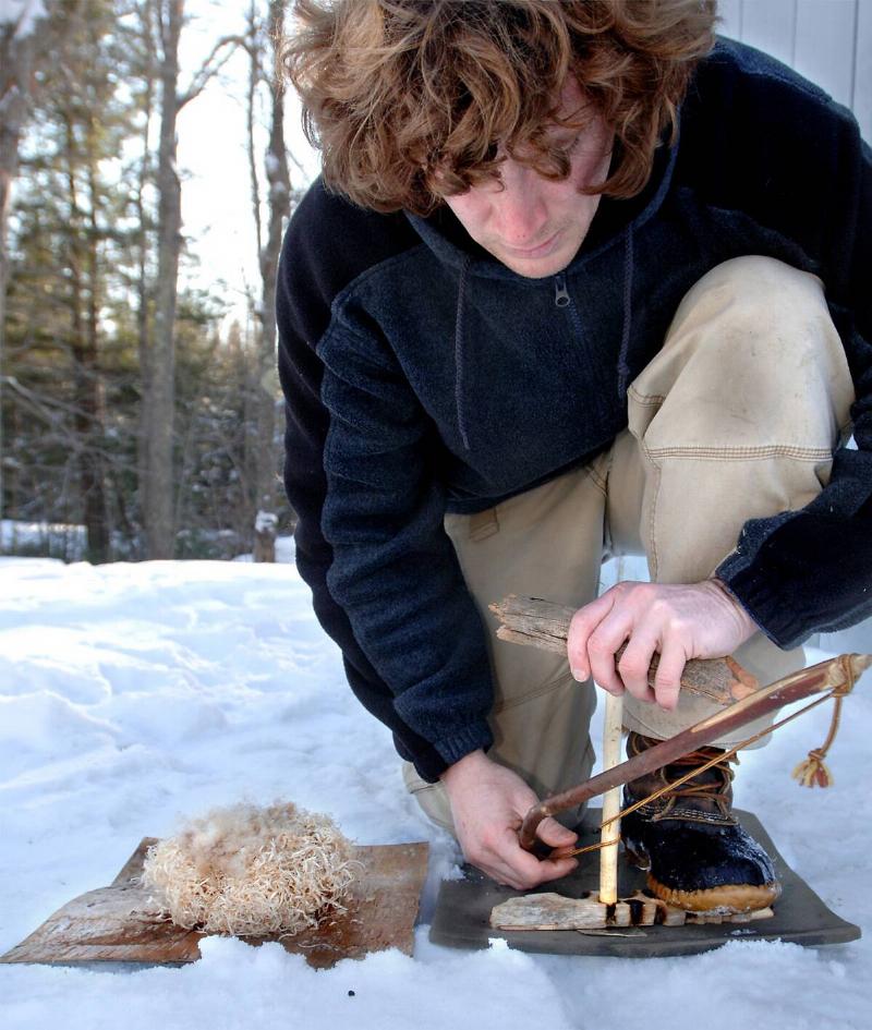 Arthur Haines shows a primitive technique for starting a fire with wood bow drill and tinder to be ignited with embers he creates from the bow drill.