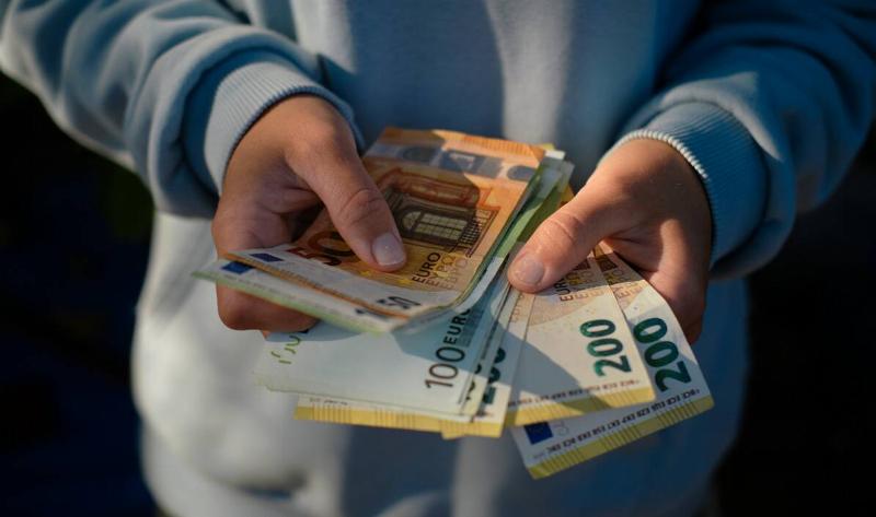 A person counting a stack of Euros.