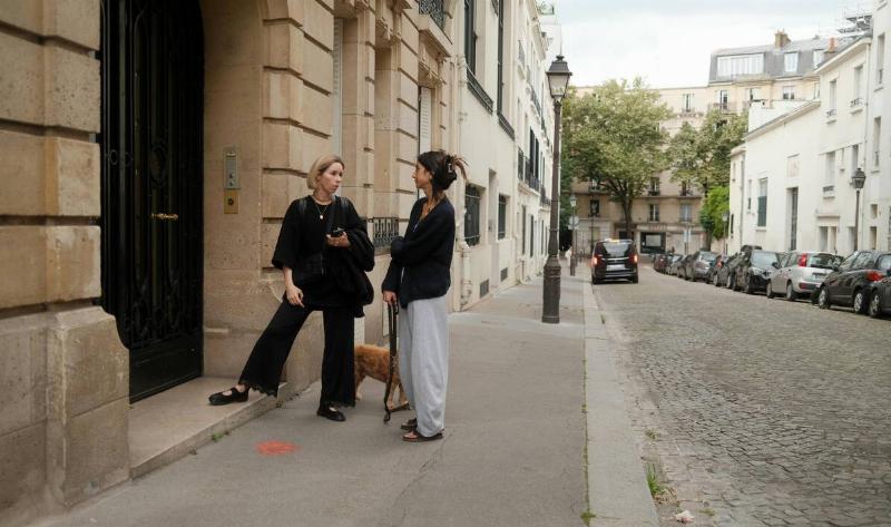 Two women on the street, talking.