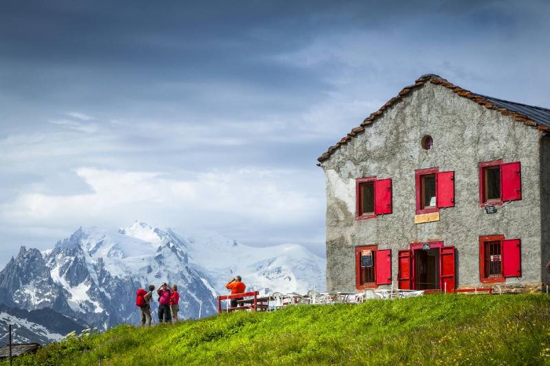Hikers looking at Mount Blanc from Refuge du Col de Balme at the Swiss-French border, Alps; France