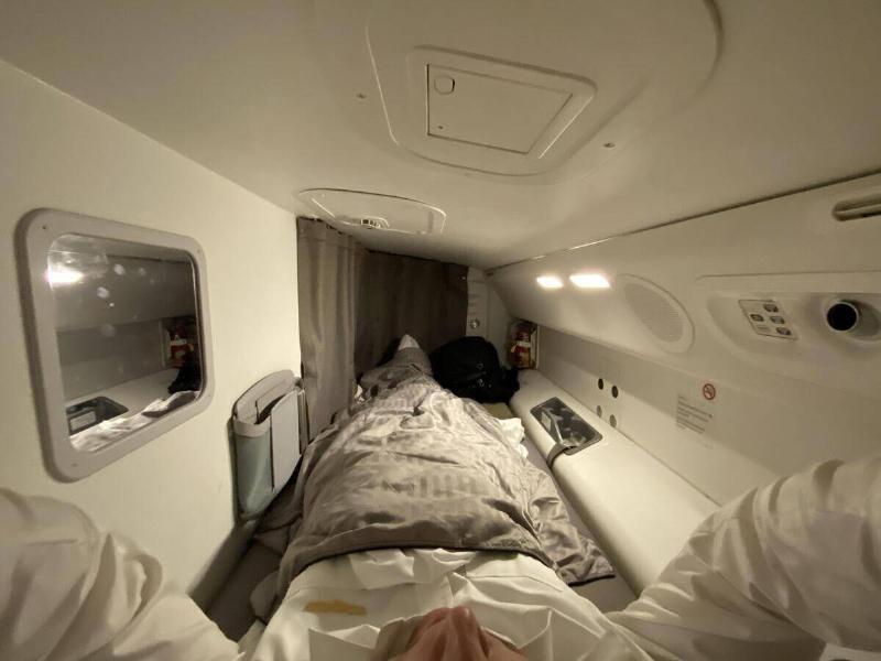 A POV photo from a man laying in one of the crew cabin beds on a Boeing 787 airplane.