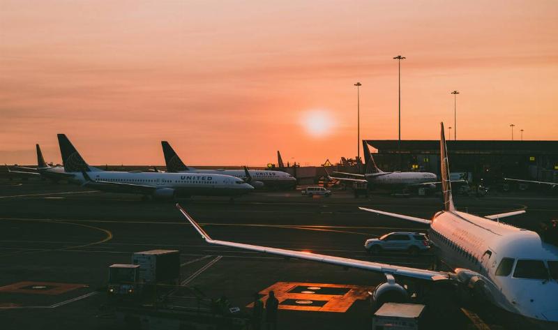 Multiple planes in the yard of an airport.