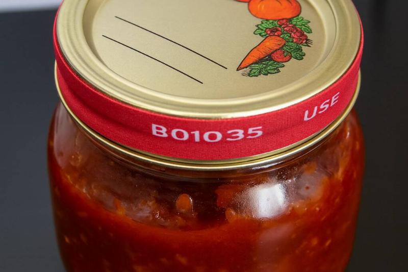 A rubber band wrapped around the lid of a pasta sauce jar. 