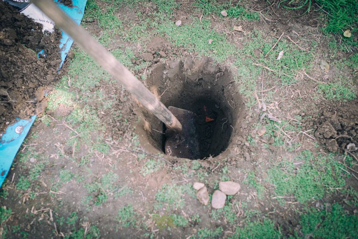 A shovel digging a hole in the dirt.