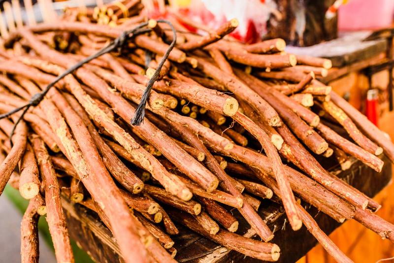 Stacks of dried licorice branches for sale.
