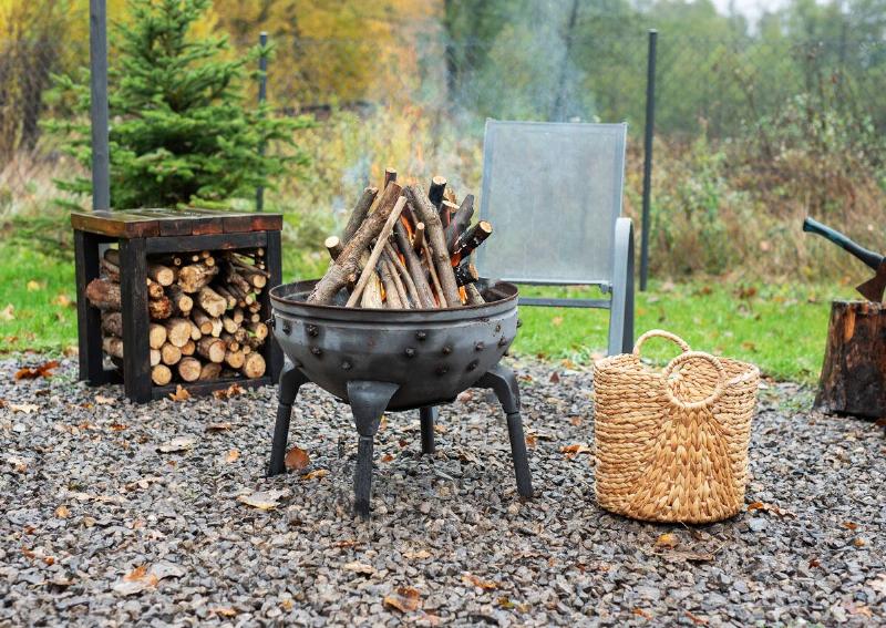Iron fire pit and burning fire in a garden