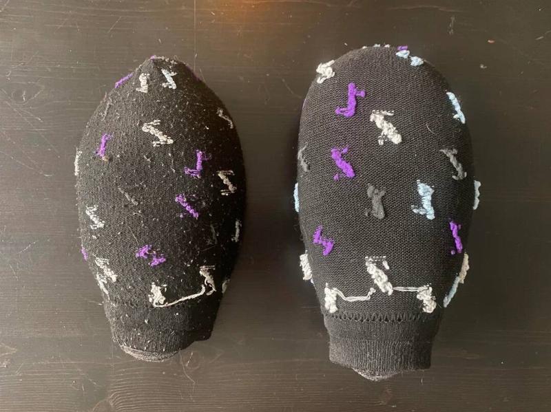 Two socks full of rice, the one on the left more worn than the one on the right.