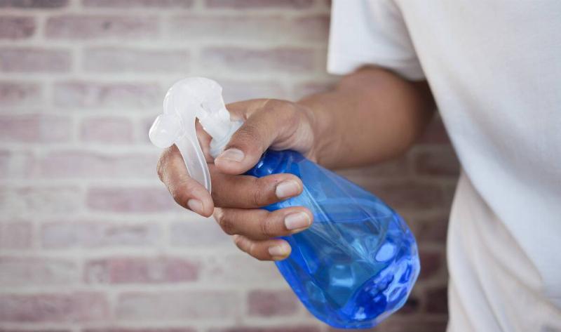 A person holding a spray bottle.