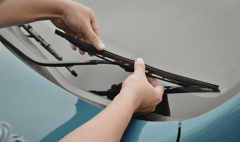 A person wiping their wiper blade.