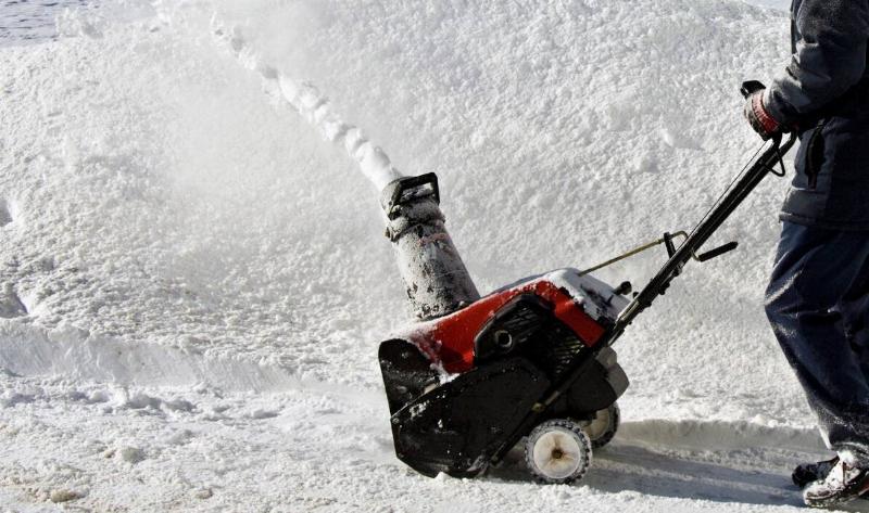 A person pushing a snowblower.