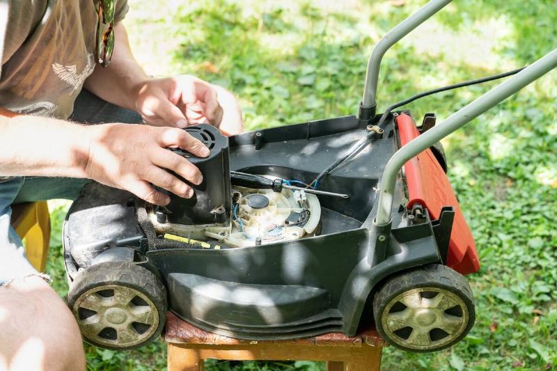 A person fixing a lawnmower engine.