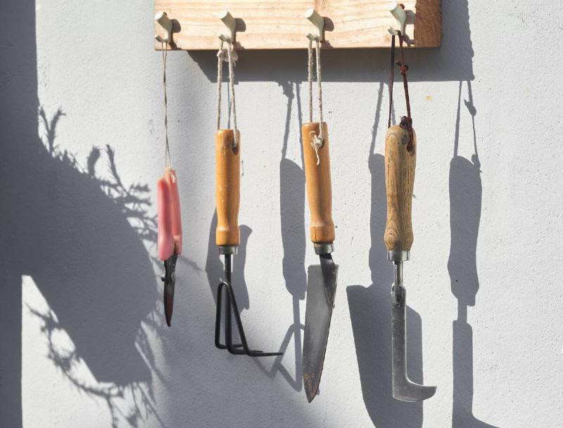 Gardening tools hanging from a rack.