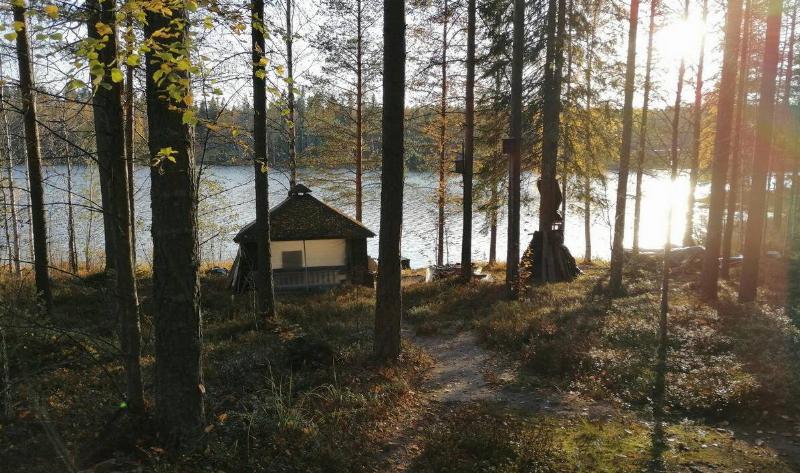 A small cabin in the woods next to a large river.