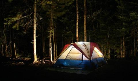 A tent at night, a light emminating from within.
