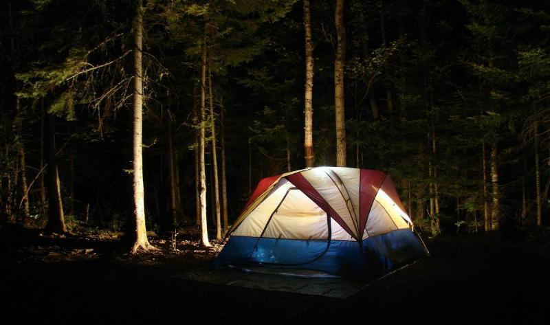 A tent at night, a light emminating from within.