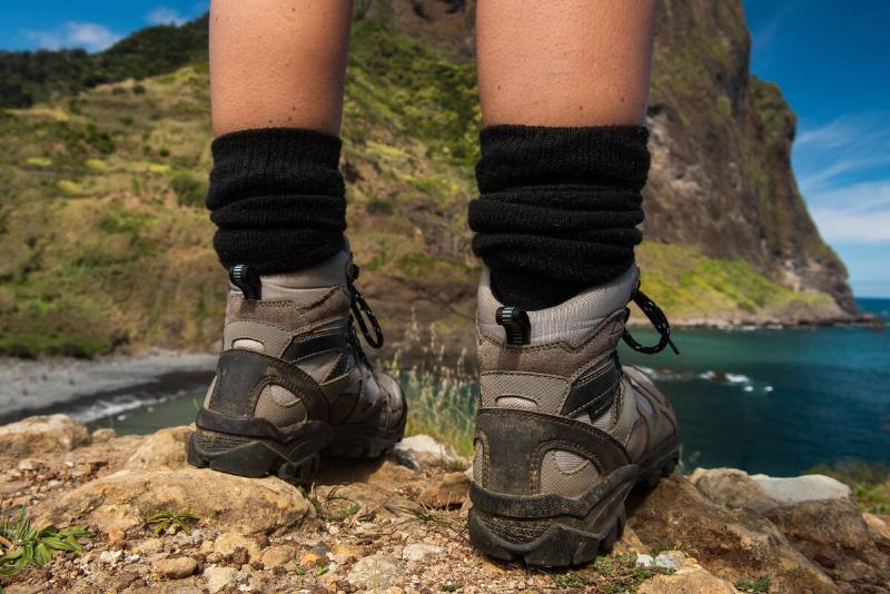 Close up portrait from behind woman standing on rock with hiking boots