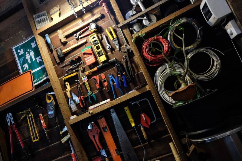 tool-and-equipment-in-a-workshop-2024-12-01-12-29-19-utcA tilted angle shot of a garage's organized wall storage full of tools.