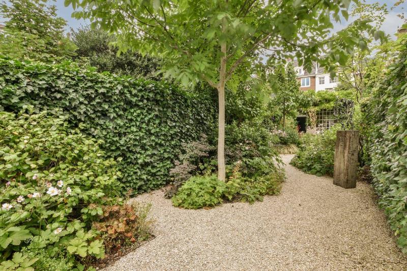 Simple small patio with small garden near wooden fence