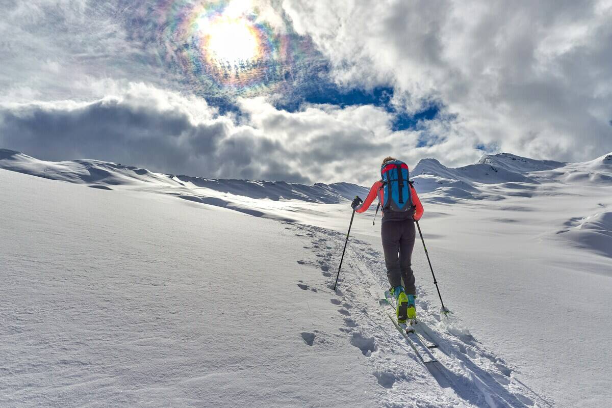 A person hiking up a mountain range in snowshoes.