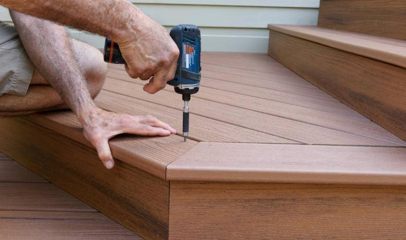 A person drilling a deck together.