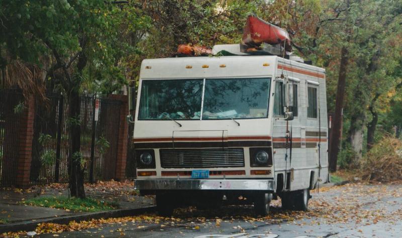 A vintage RV parked on the street.