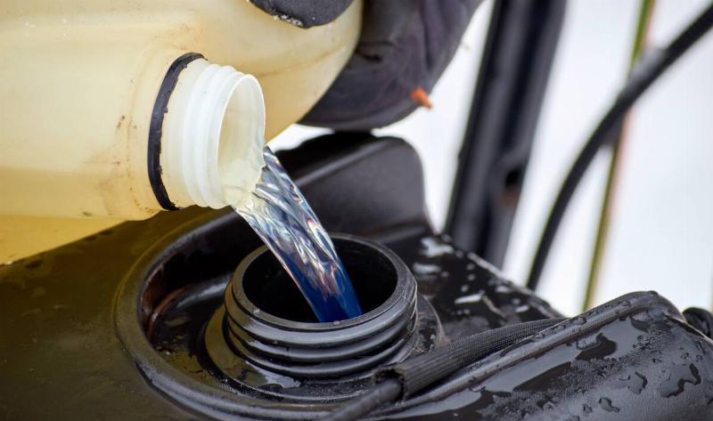 Gas being poured into a snowblower tank.