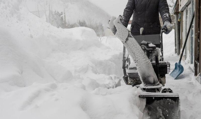 A snowblower blowing snow.