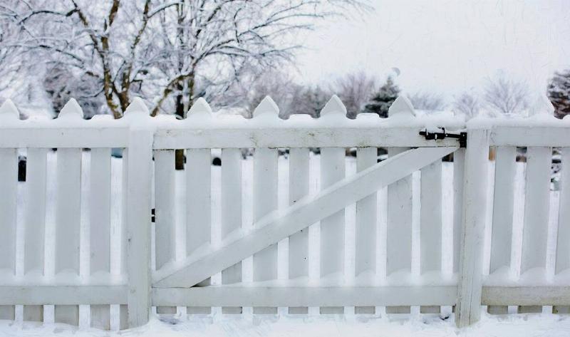 A wooden fence with snow on it.5