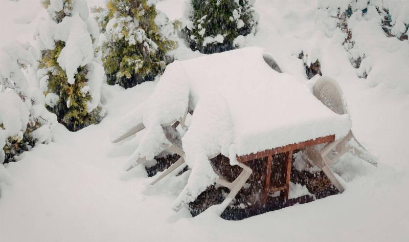 A picnic table and chairs covered in snow.