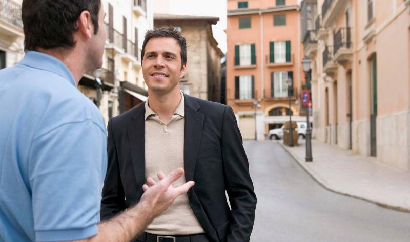 Two men talking on the street.