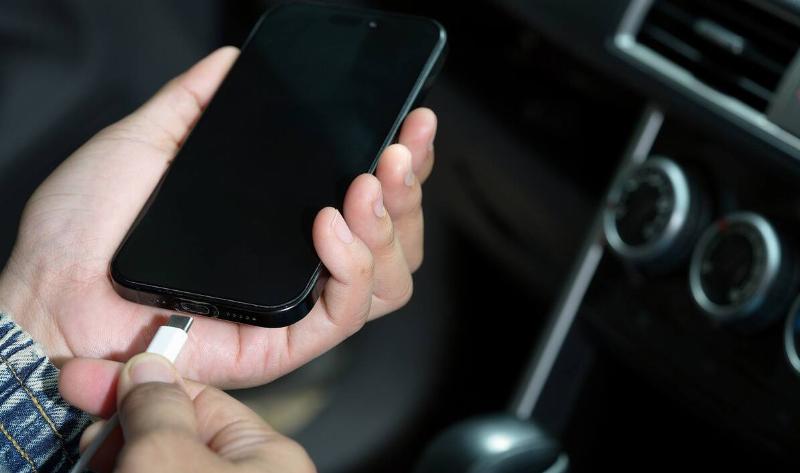 A person plugging a charger into their phone.