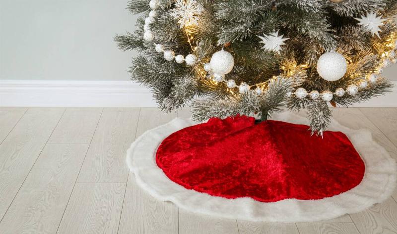 A christmas tree with a tree skirt on.