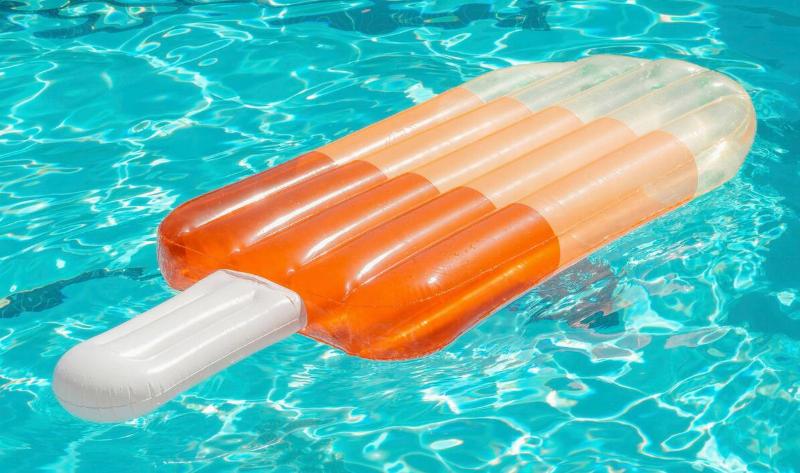 A large, popsicle-shaped pool floatie in the water.