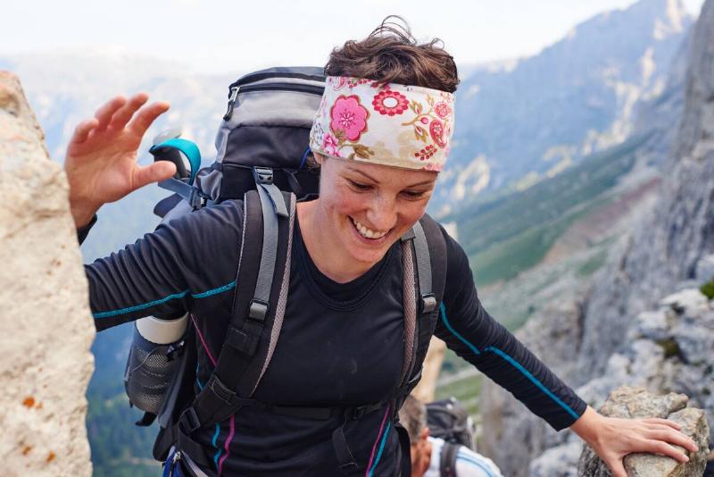 Woman hiking up mountain smiling, Austria
